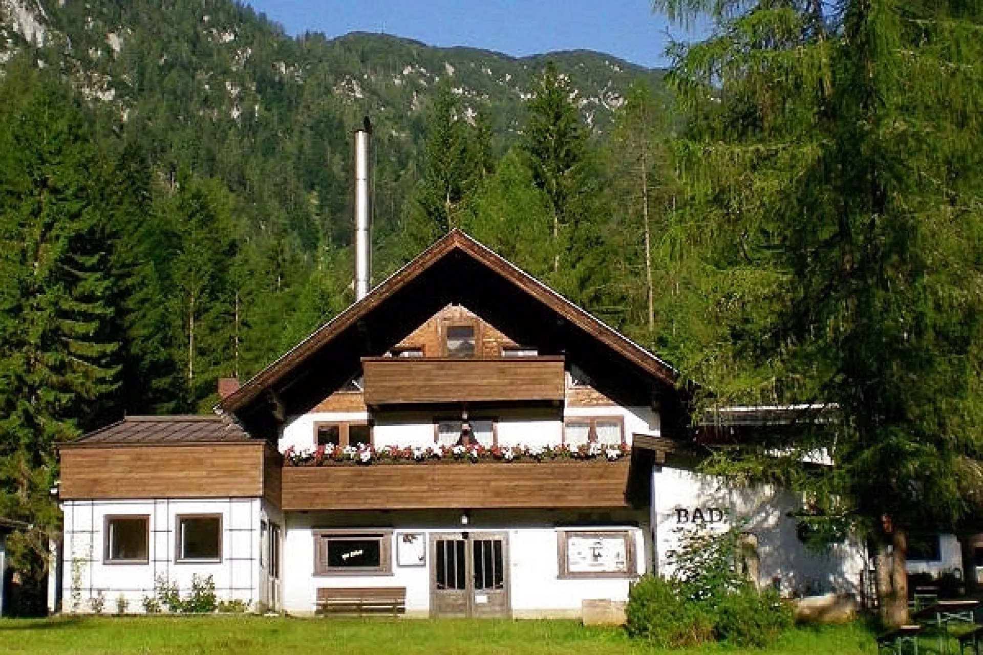 Brennerei Josef Mack umgeben von Bergen und Bäumen