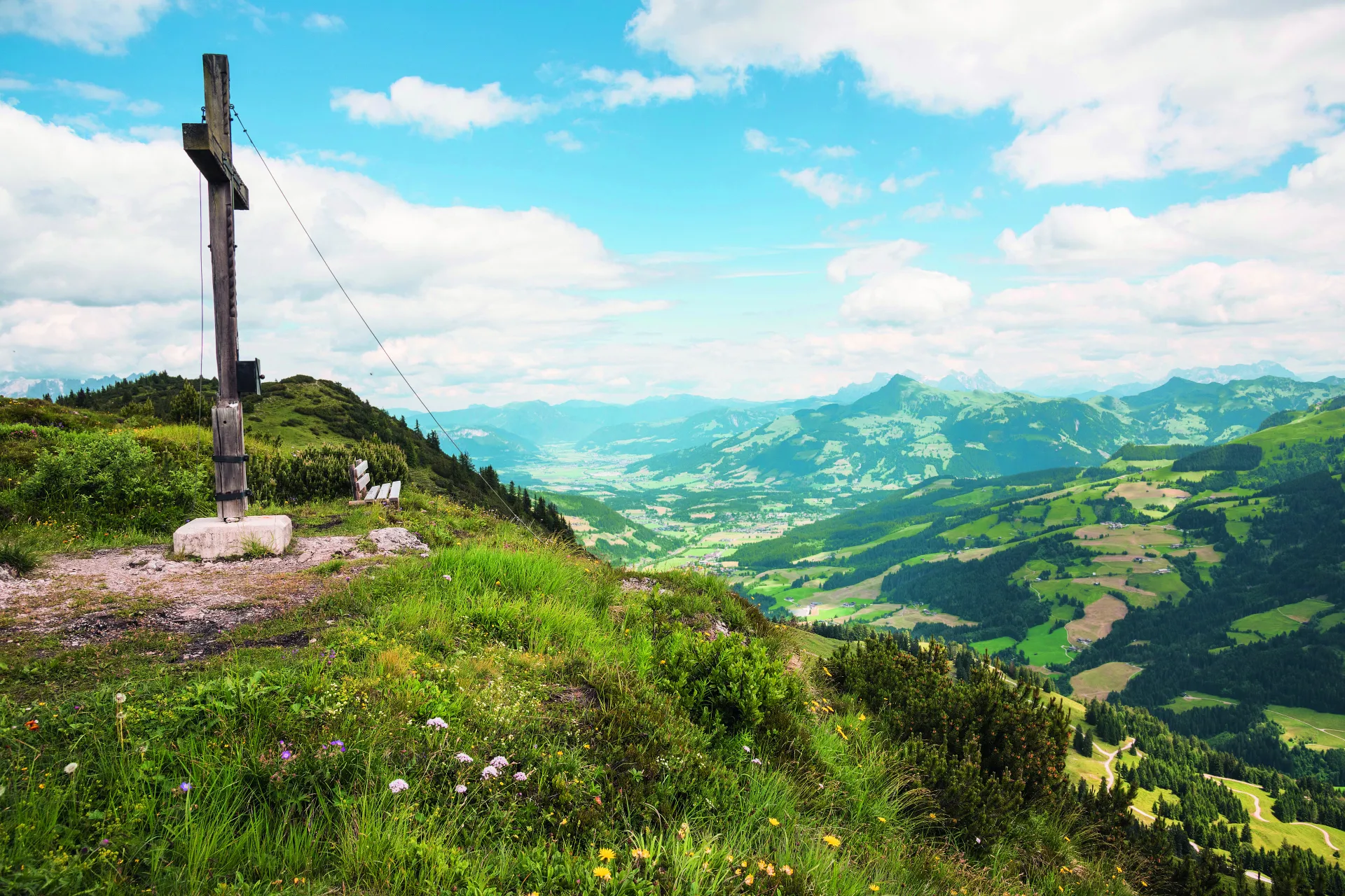 Gipfelkreuz auf dem Gaisberg in Kirchberg in Tirol mit Berglandschaft im Hintergrund