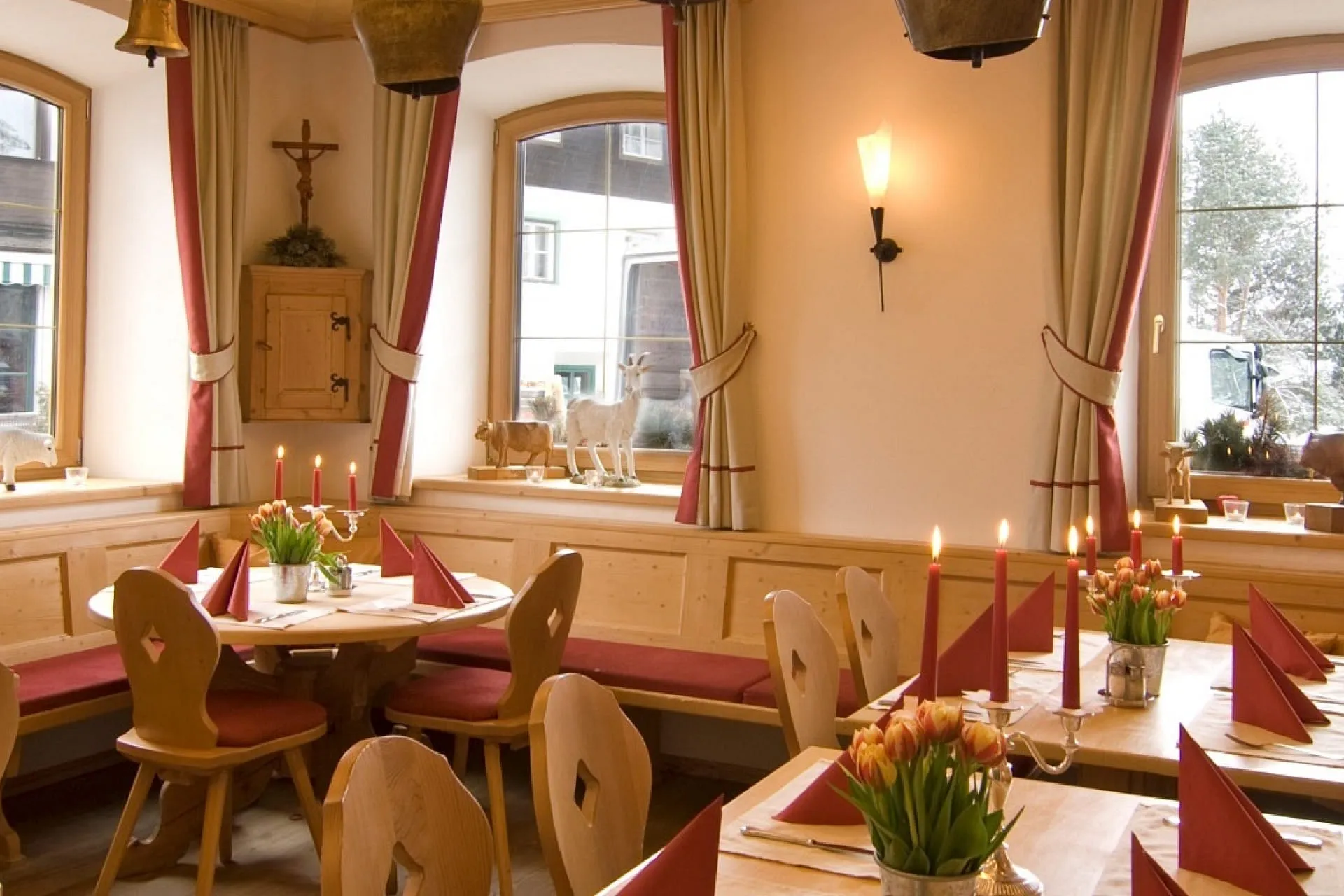 Gemütliches Restaurant mit Holztischen und Blumenarrangements