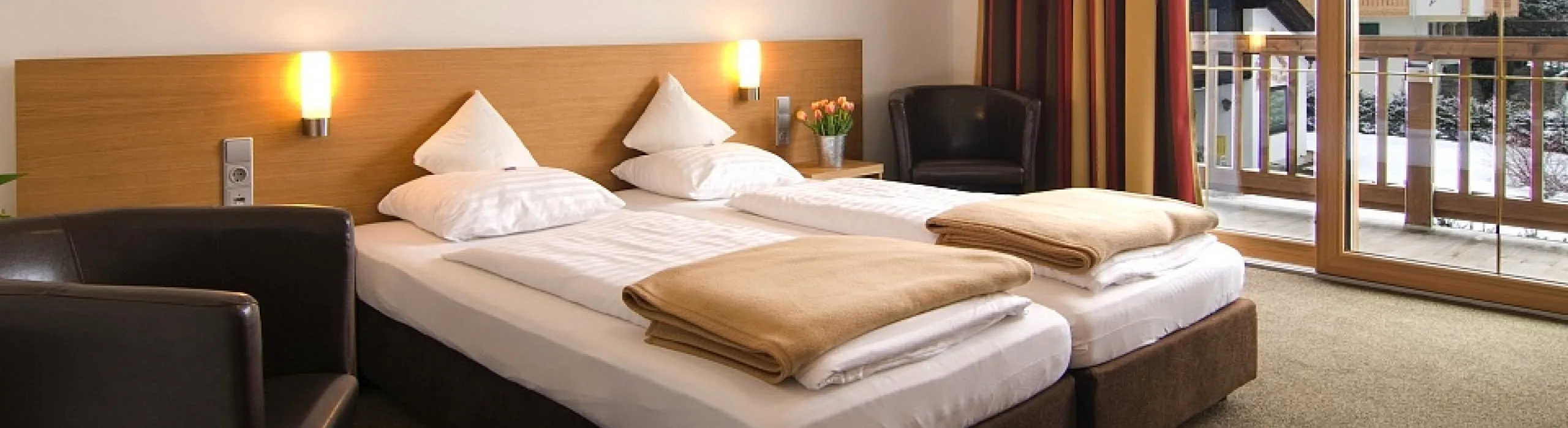Helles Doppelzimmer mit zwei Betten, Sesseln und Balkon