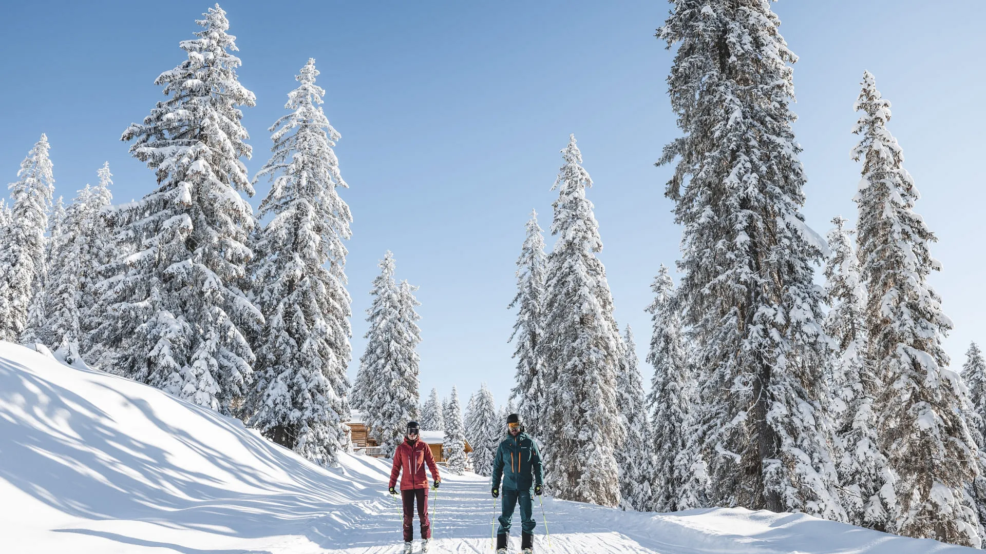 Zwei Skifahrer in Winterlandschaft mit schneebedeckten Bäumen